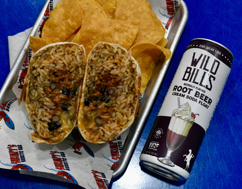 Tray with tortilla chips, rice dish, and Wild Bills Root Beer can on a blue surface