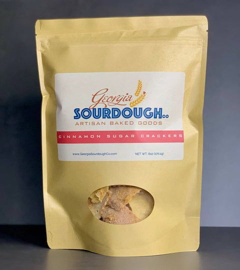 Gold packaging of Georgia Sourdough Cinnamon Sugar Crackers on a dark background