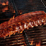 Grilled ribs on a barbecue grill with flames