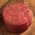 Raw steak on a wooden cutting board