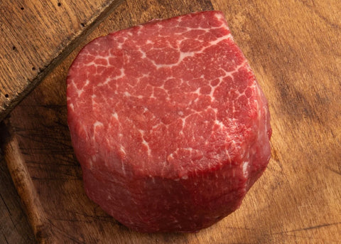 Raw steak on a wooden cutting board