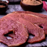 Raw meat on a marble surface with spices in the background