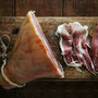 Raw cured meat on a wooden cutting board with a dark background